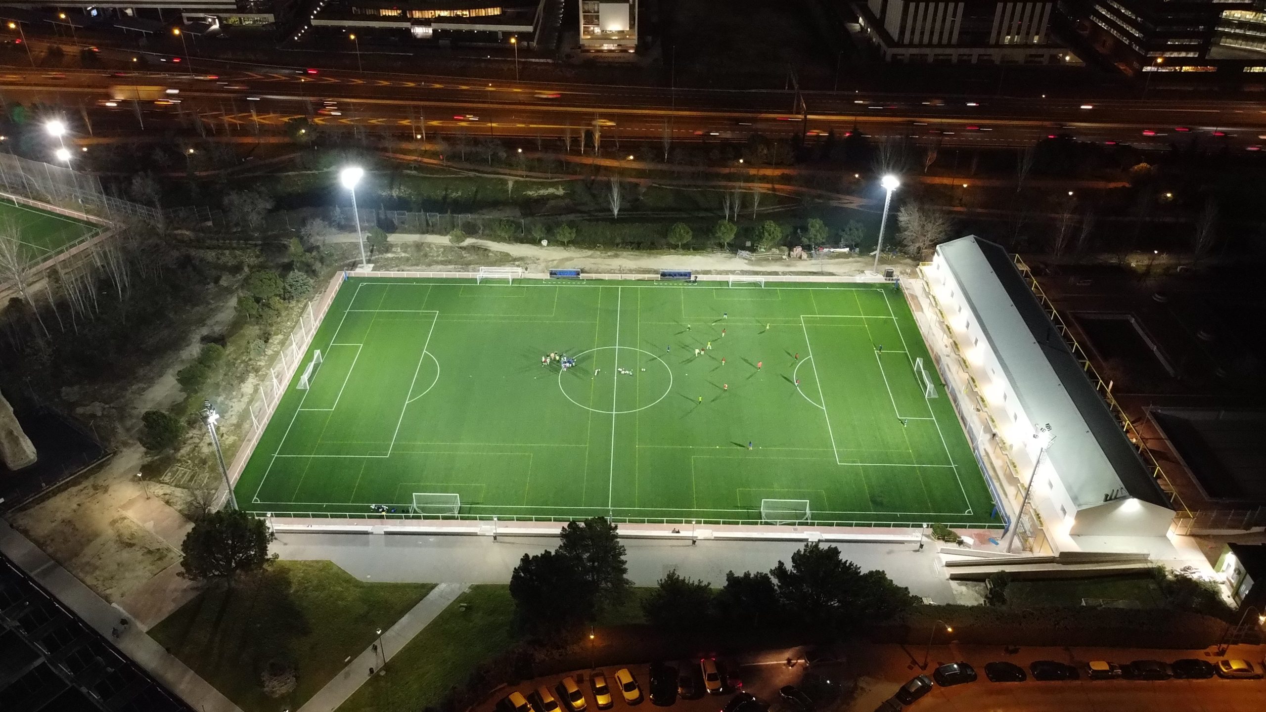 Panorámica de campo de fútbol con postes de iluminación led